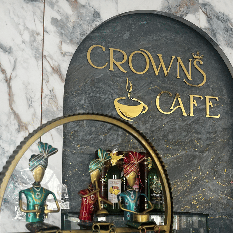 Painted figurines in a brass ring beneath the Crown Cafe sign