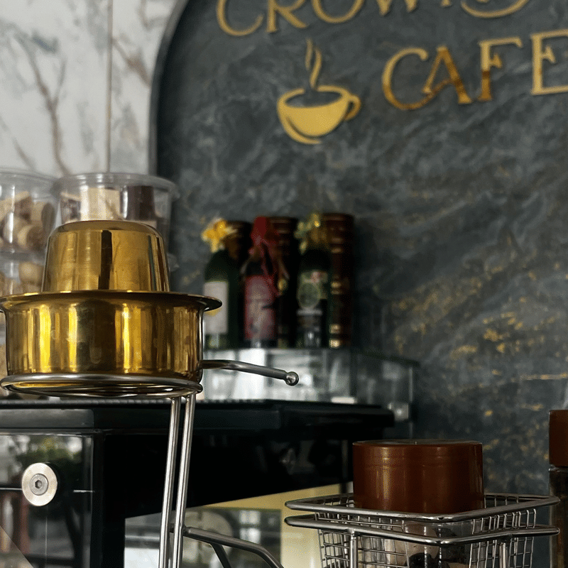 A brass Coorg filter coffee pot on the Crown Cafe counter