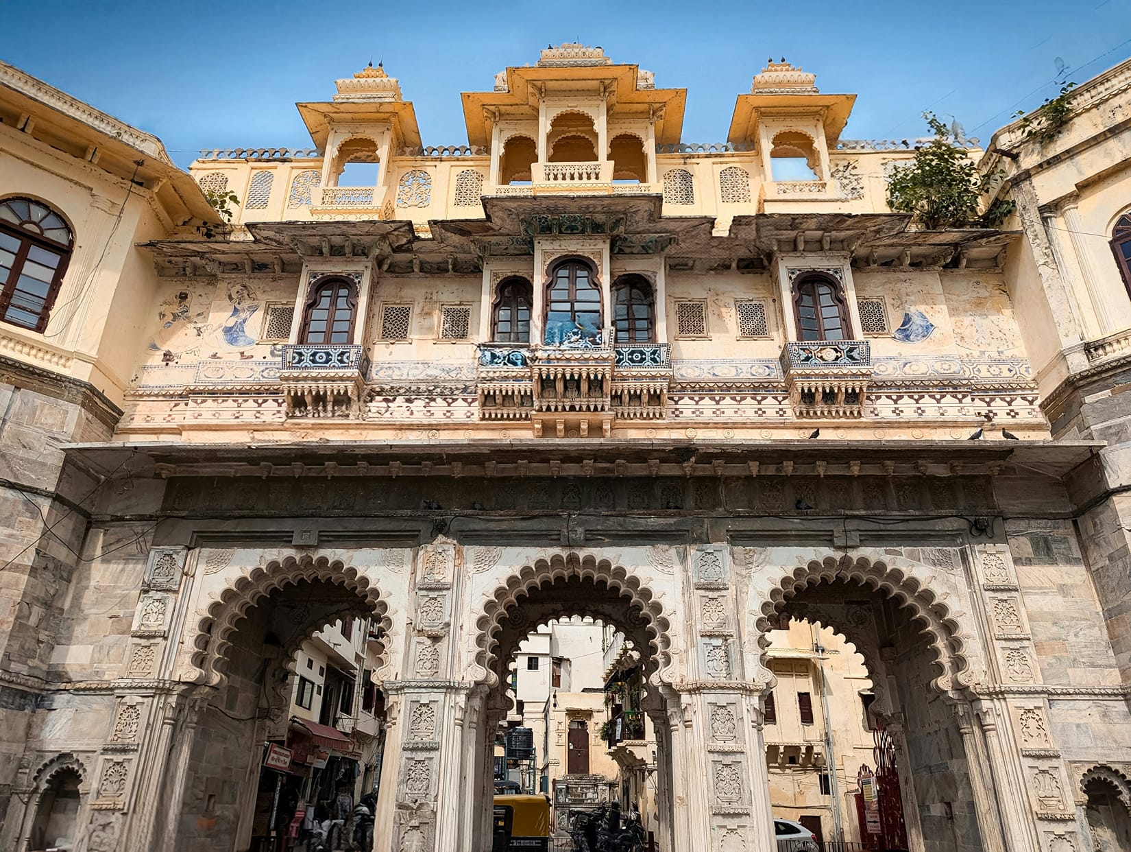 The grand facade of a historic stone building of Bagore Ki Haveli featuring detailed archways and balconies