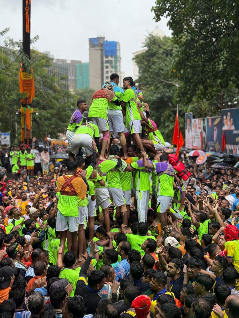 Group forming a human pyramid to break a clay pot suspended overhead during Matki Phod celebrations in Udaipur