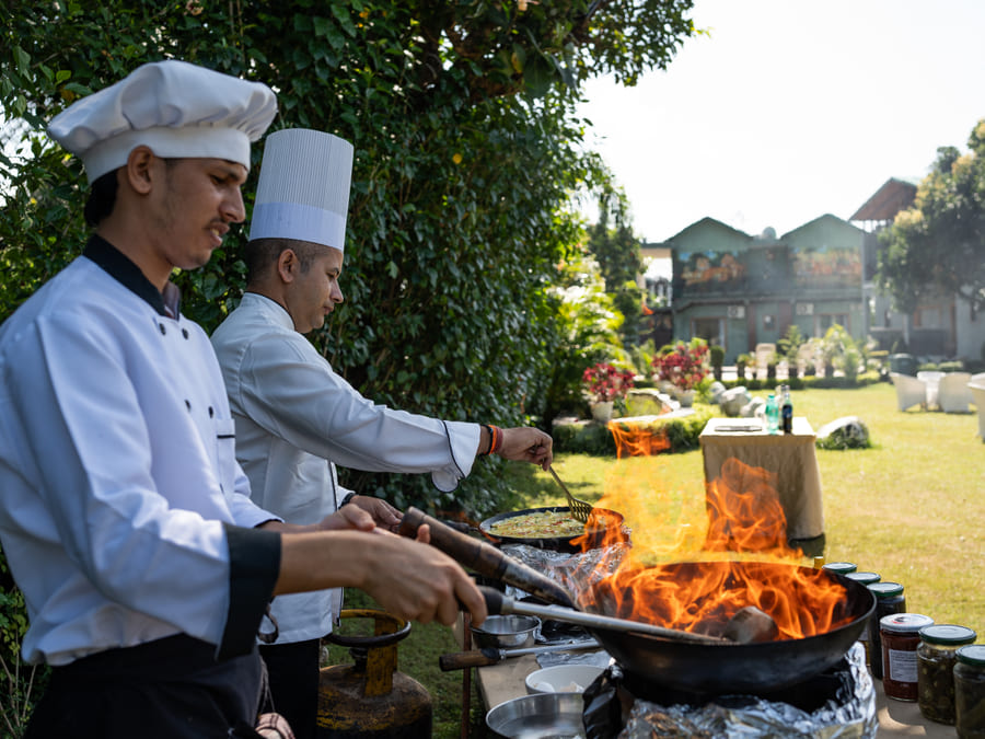 Chefs cooking with fire outdoors