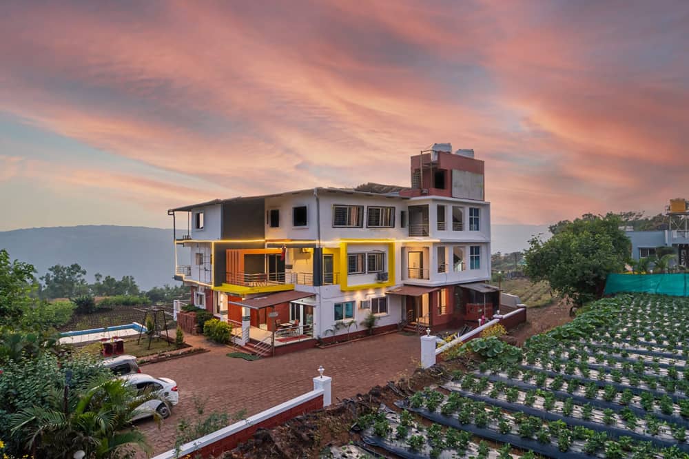 Strawberry King Resort at dusk under a pink sky, with strawberry rows in the foreground