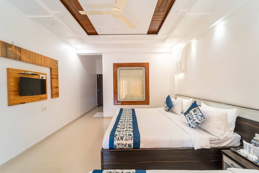 Deluxe Valley View Room with a king bed, a blue floral runner and a wall TV