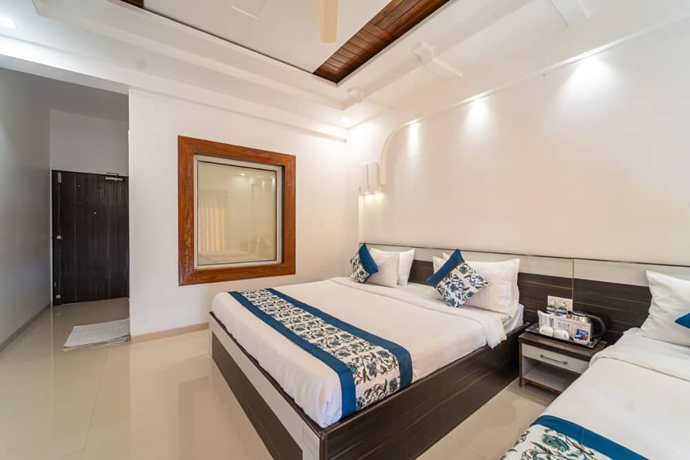 Deluxe Valley View Room with a king bed, a side table and a decorative wall mirror