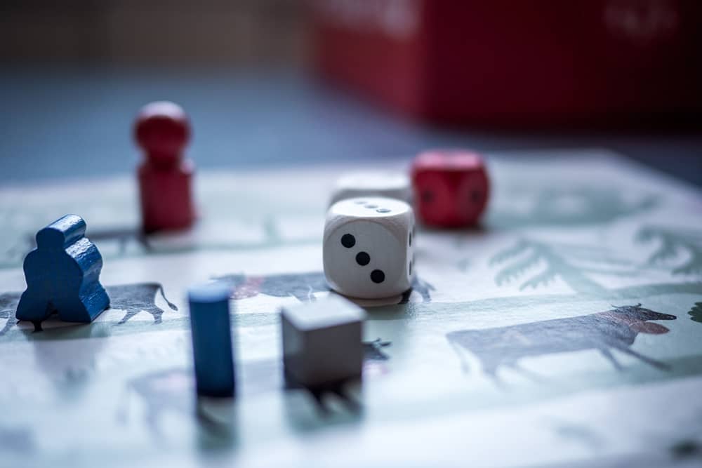 Board game pieces and dice on a game board in close-up