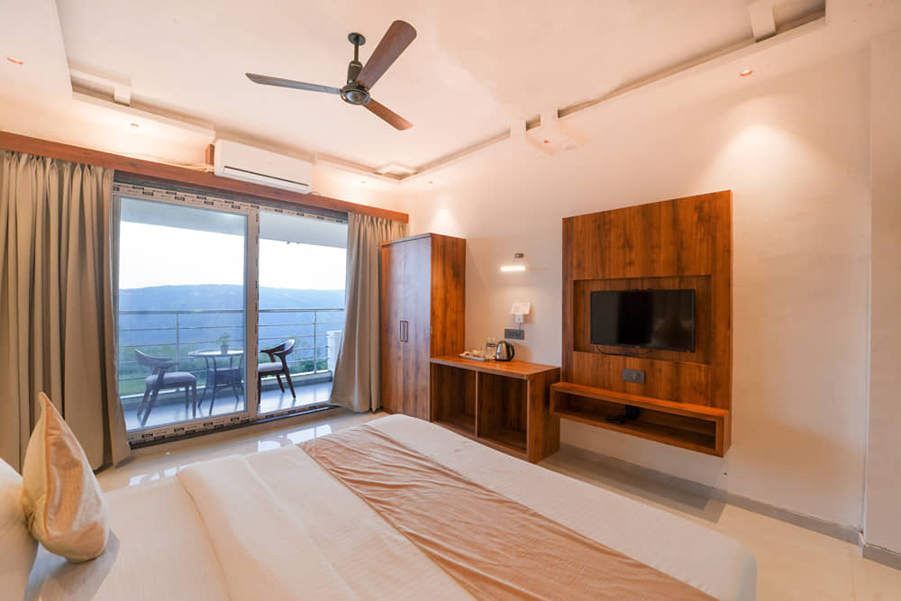 Suite Room with a king bed and sliding doors onto a balcony with valley views
