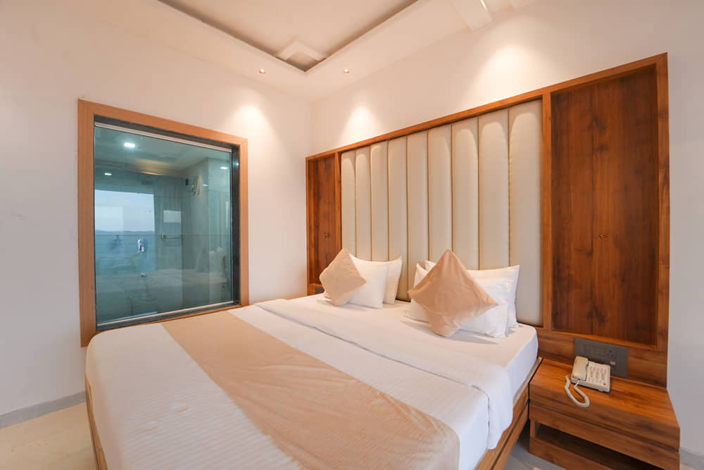 Suite Room bed with wooden panelling and a bedside table with a telephone
