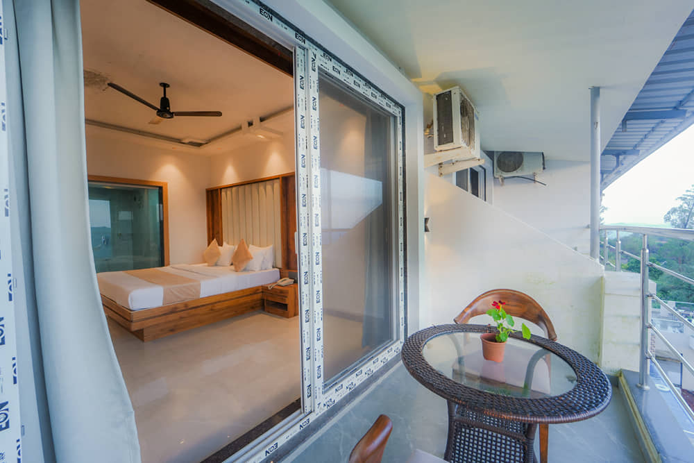 Suite Room balcony with sliding glass doors, a round table and two chairs