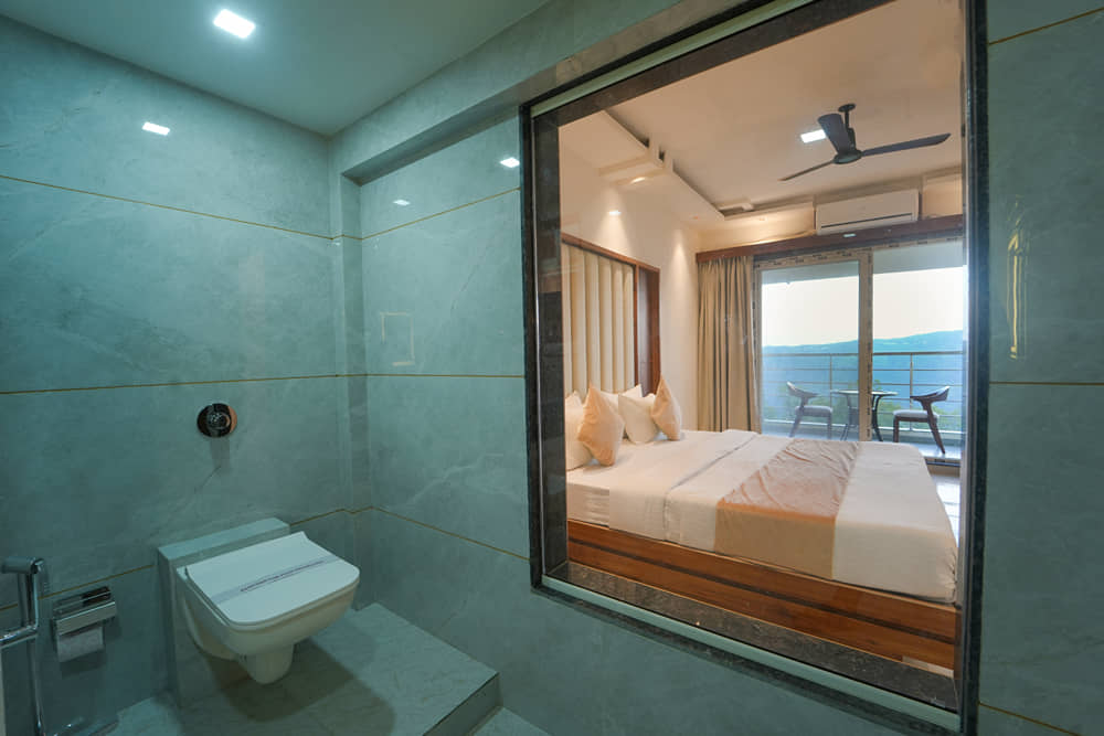 Suite Room bathroom with a glass partition, a wall-hung toilet and a large mirror