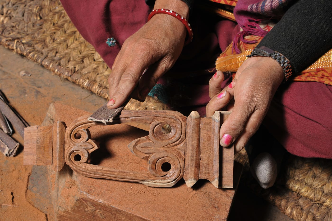 A craftsman carving a temple strut by hand at Nepali Ghar Hotel