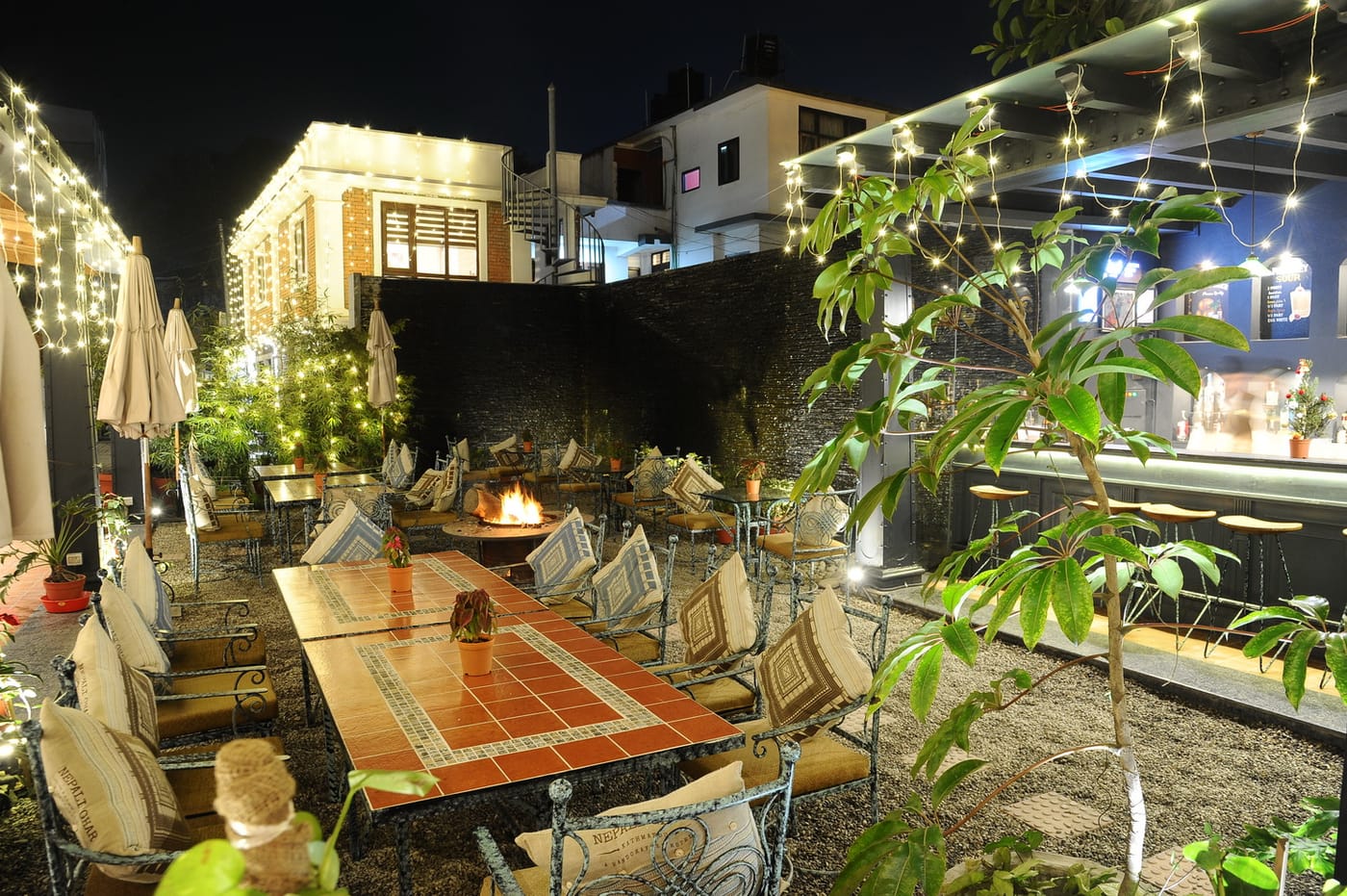The garden laid for dinner under strung lights at Nepali Ghar Hotel