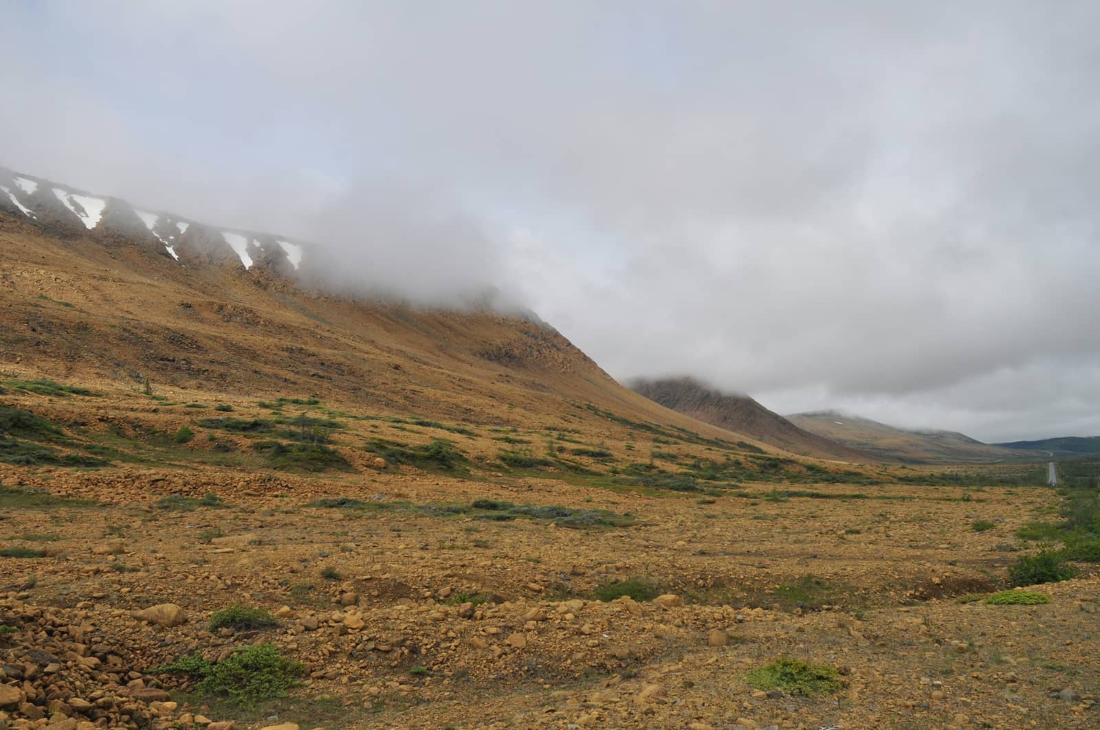 A vast highland plateau with mist-covered hills in the distance
