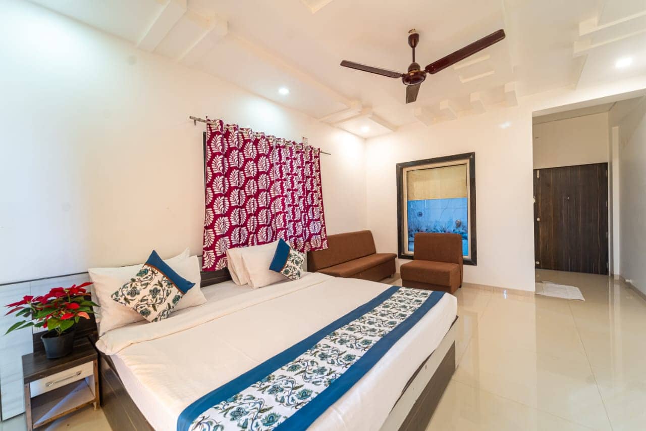 Deluxe Garden View room with a king bed, blue and white linen and a patterned screen