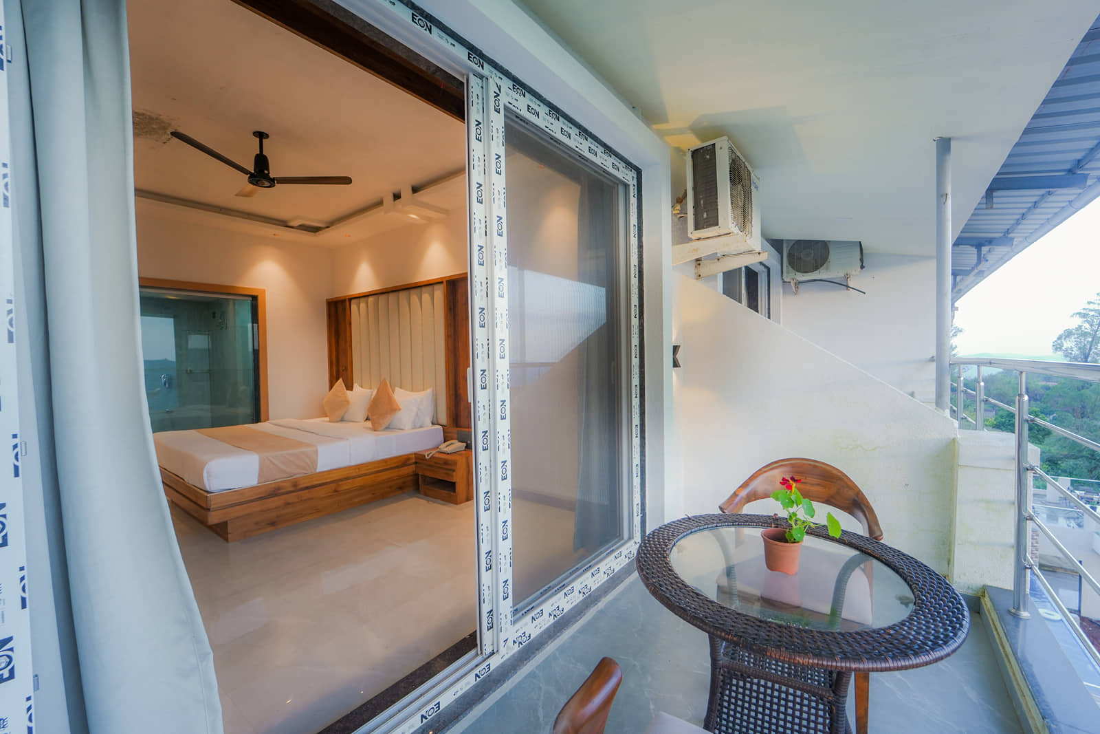 Suite Room balcony with sliding glass doors, a round table and two chairs