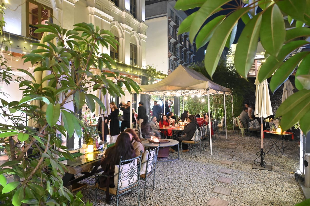 Daytime dining under parasols among the planting in the garden courtyard