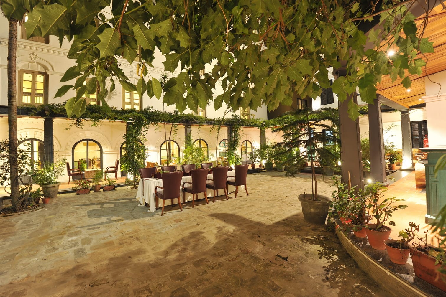 A long table set beneath the vine-covered veranda in the courtyard at Chiya Pasal