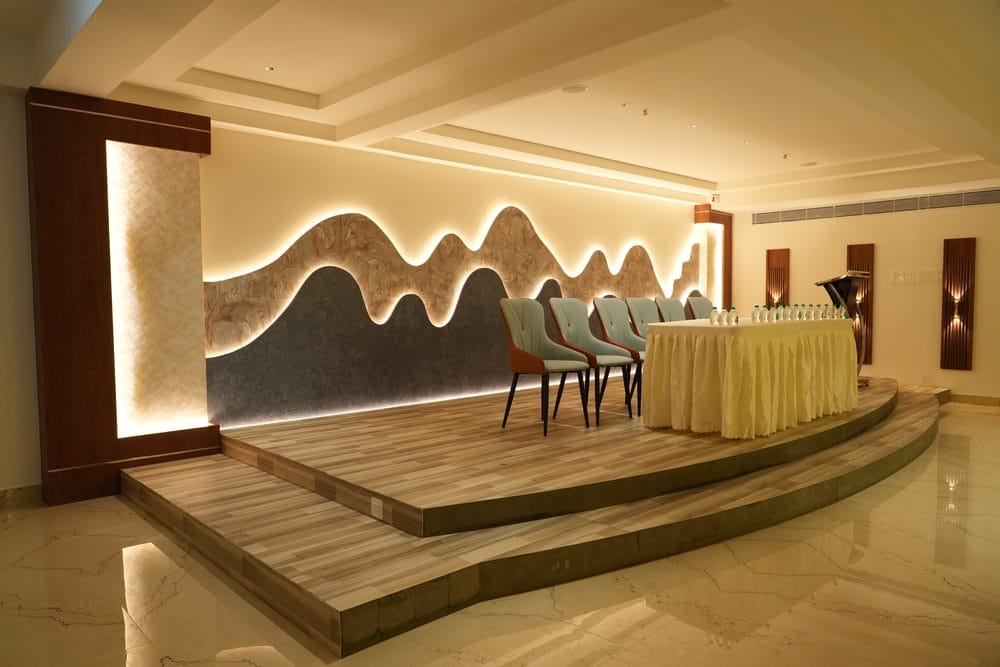The raised timber stage at Grand Gathering, with a lectern, head table and a backlit sculpted feature wall