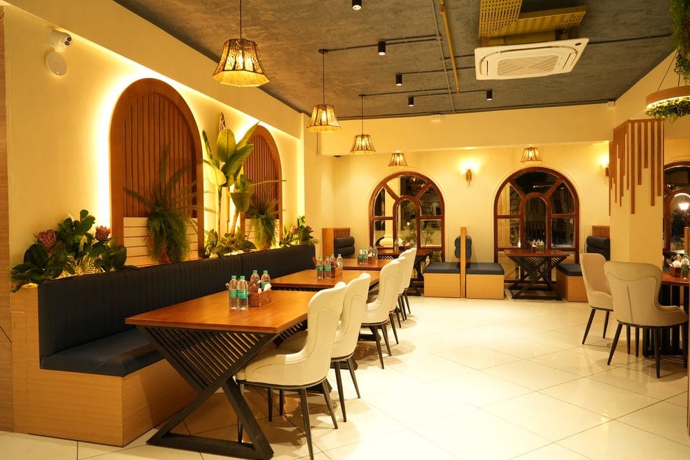 Golden Garnish restaurant, with long banquette seating beneath planted timber arches and woven pendant lights