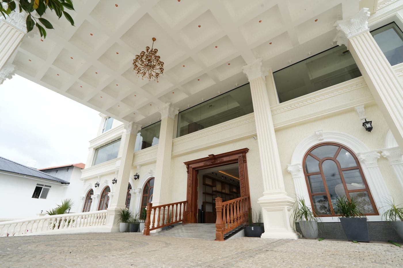 Chandelier hanging beneath the coffered entrance porch, above the carved timber main door
