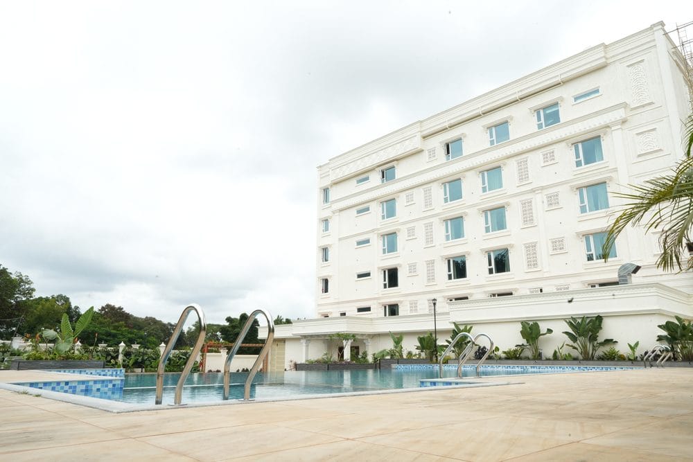The swimming pool and its stainless handrails, with the white resort building rising behind