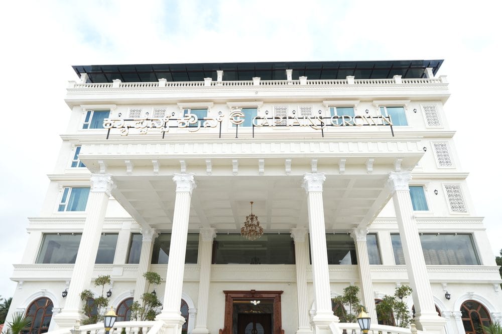 The white colonnaded facade of Captains Crown, with the hotel name in Kannada and English above the portico