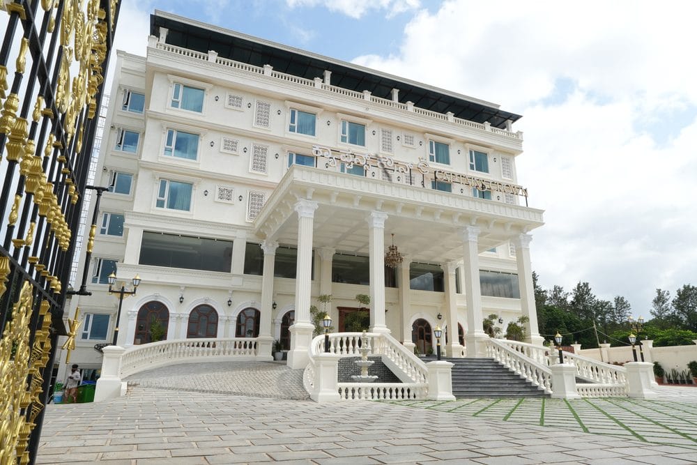 The full five-storey facade of Captains Crown seen through the ornamental main gate