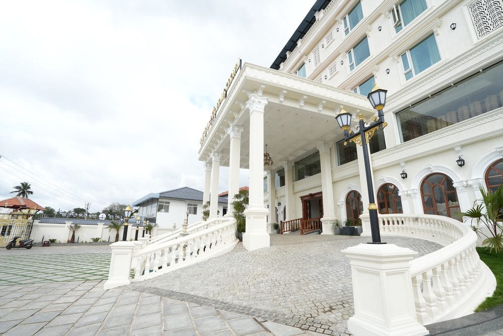 The pillared entrance portico of Captains Crown, with curved white balustrades and a cobbled drive