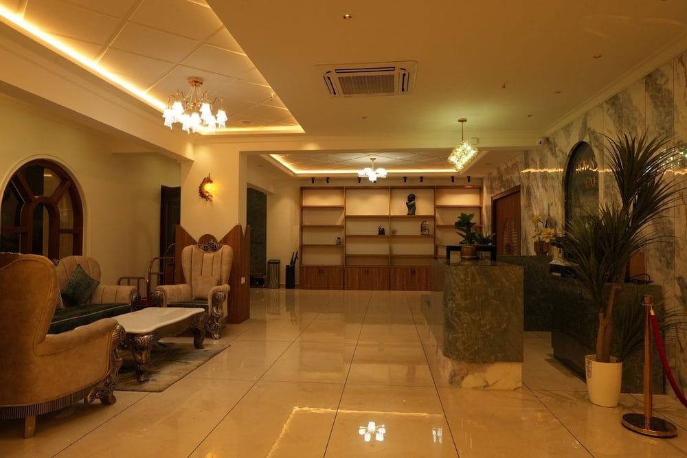 Lobby lounge at Captains Crown with carved armchairs, marble floors and the reception desk beyond