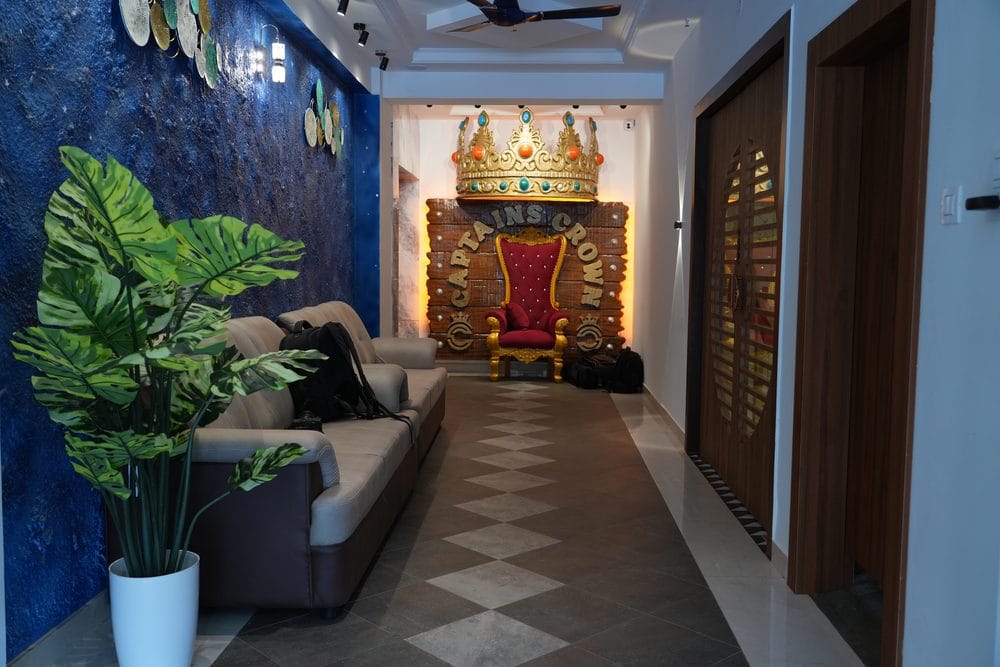 The gilded Captains Crown throne at the end of a lobby corridor, with a sofa and plants alongside