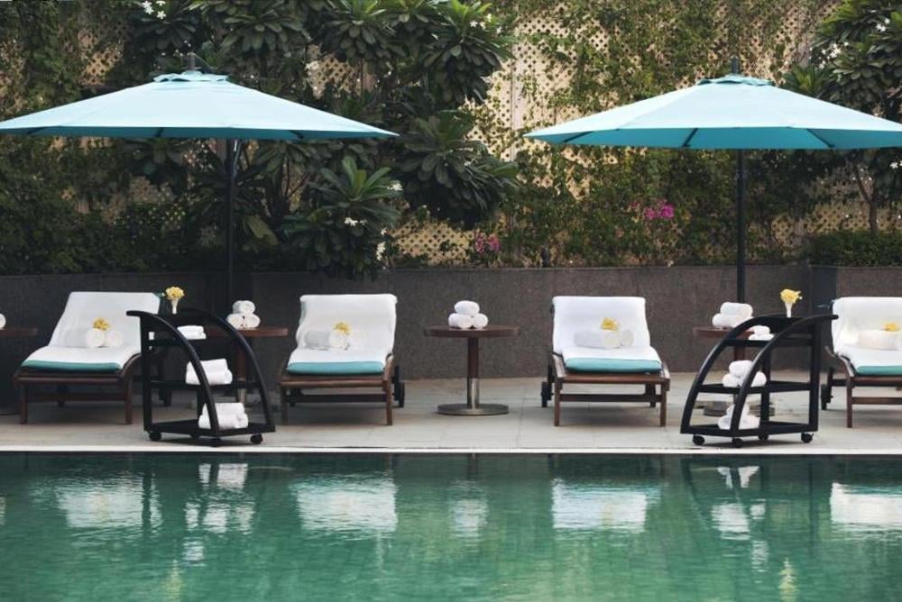Loungers and umbrellas beside an outdoor swimming pool