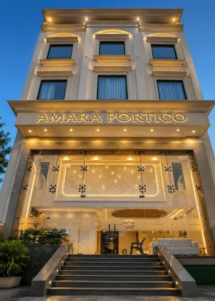 Amara Portico lit at night, the classical cream frontage picked out in gold light above the steps up to the entrance doors
