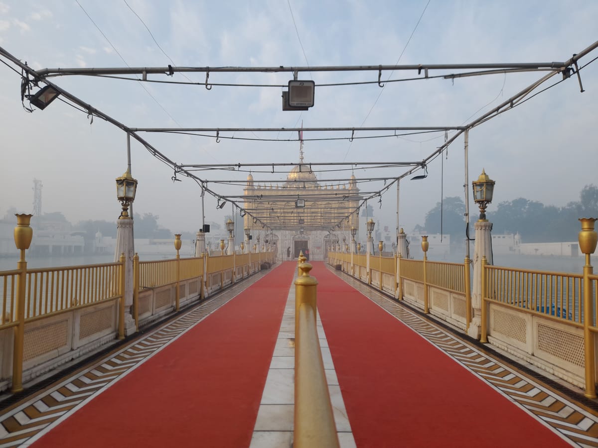 The red-carpeted causeway leading across the water towards Durgiana Temple in Amritsar, lined