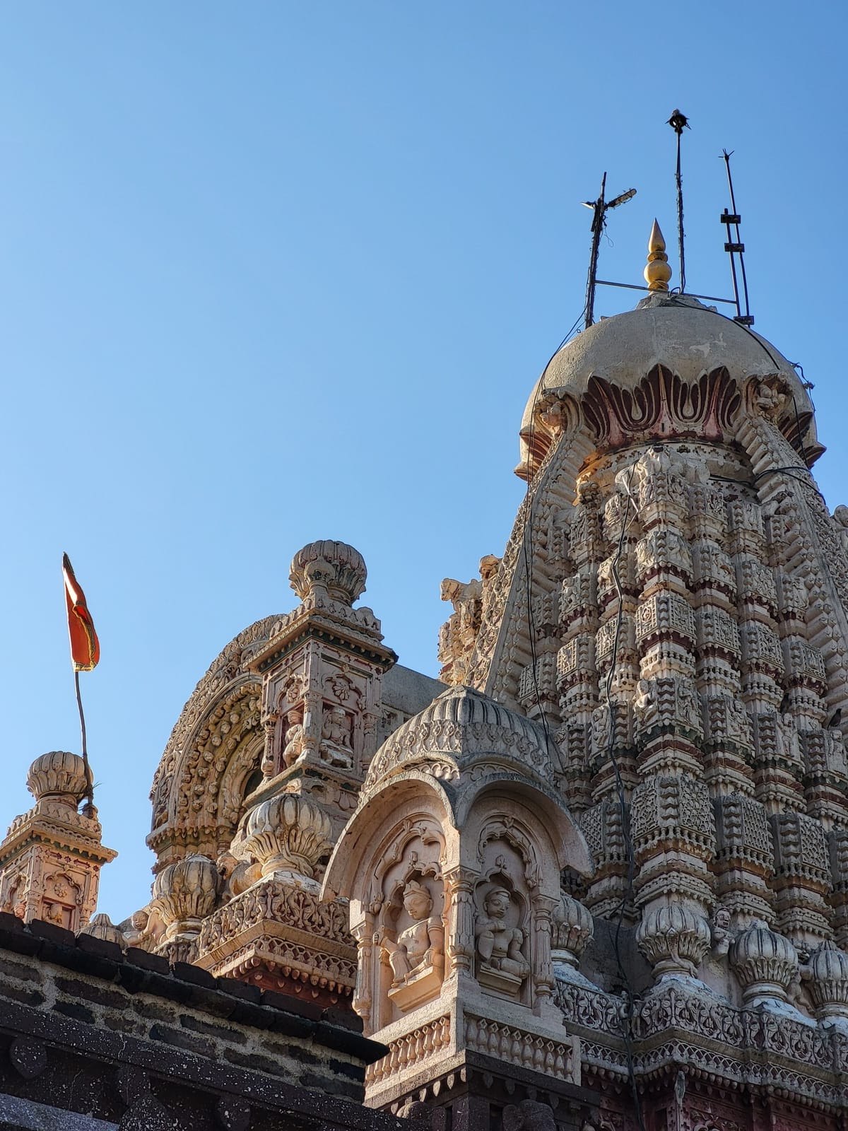 The carved stone shikhara of Rukmini Devi Mandir near Dwarka, its tiered spire rising against a clear blue sky