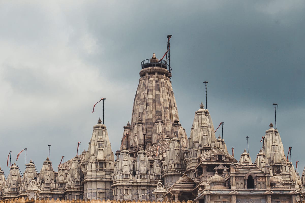 The clustered marble spires of the Jain temple complex near Dwarka, carved in tiers against a grey sky