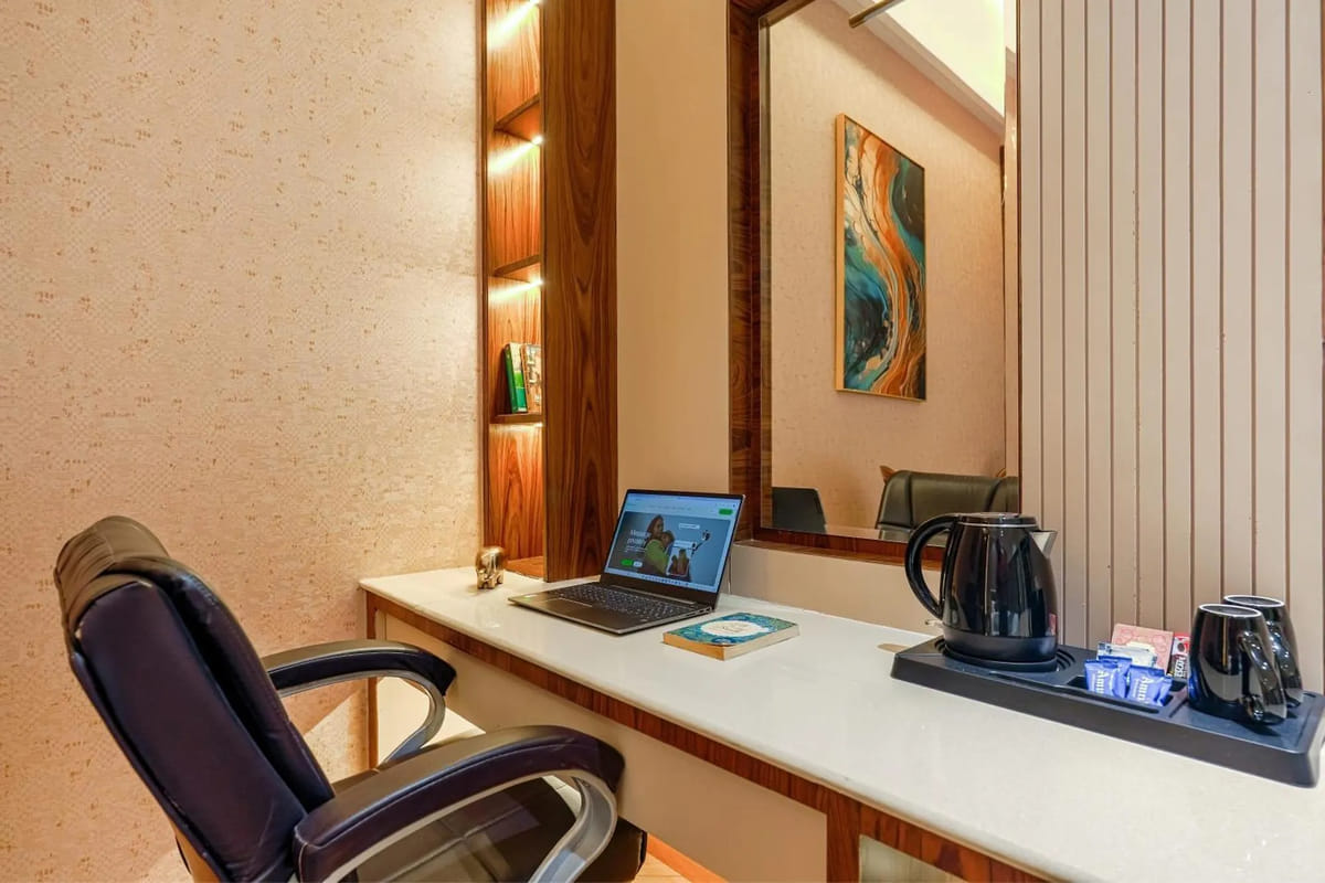 The work desk in a Suite at Marrion Hotel, with a leather chair, a mirror above the counter and a kettle