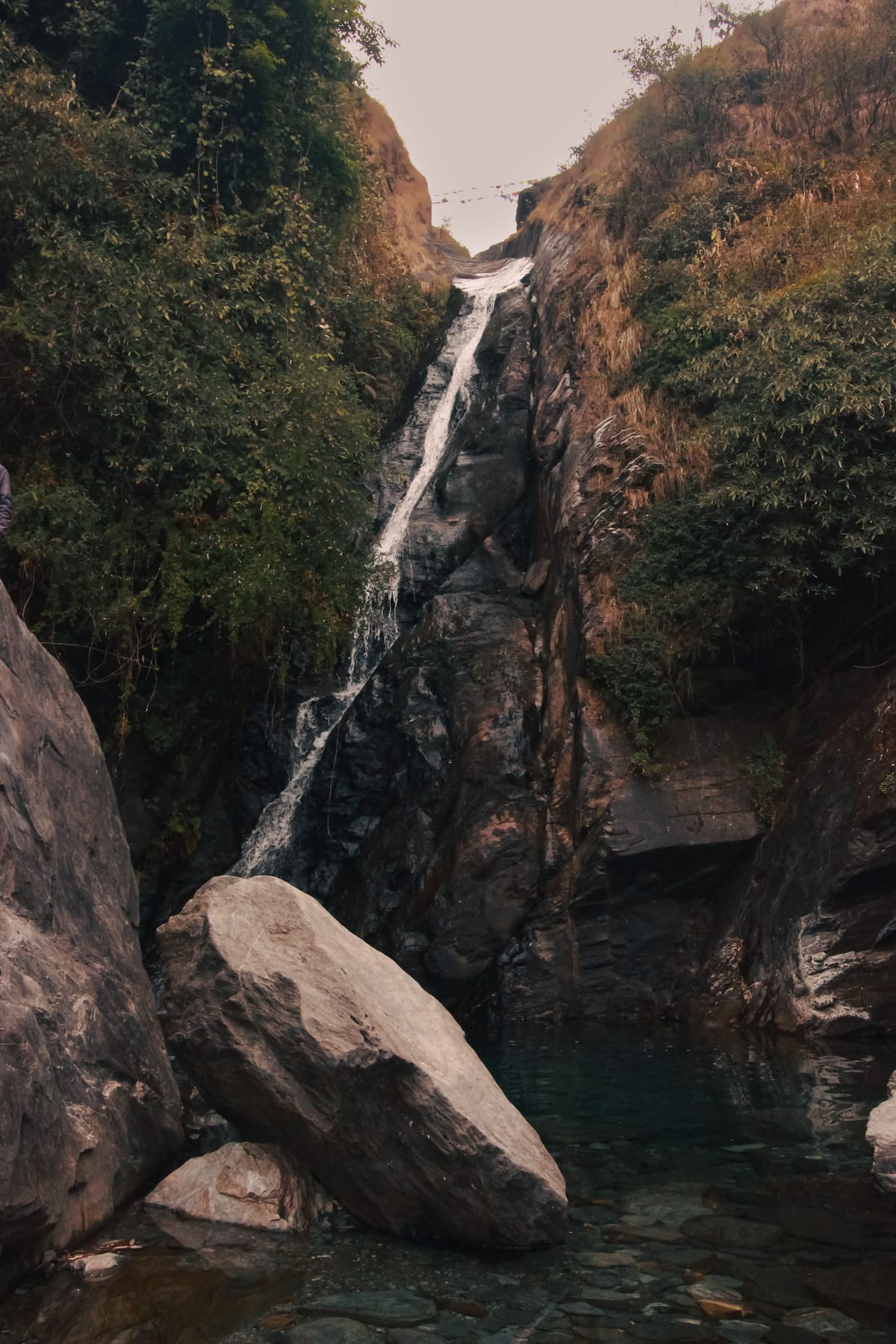 Bhagsunag Falls dropping through its rocky gorge near McLeod Ganj, boulders piled at the foot of the water