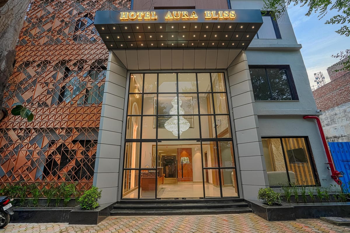 The entrance to Aura Bliss in Amritsar, a double-height glass front set into a brick lattice facade with lit signage