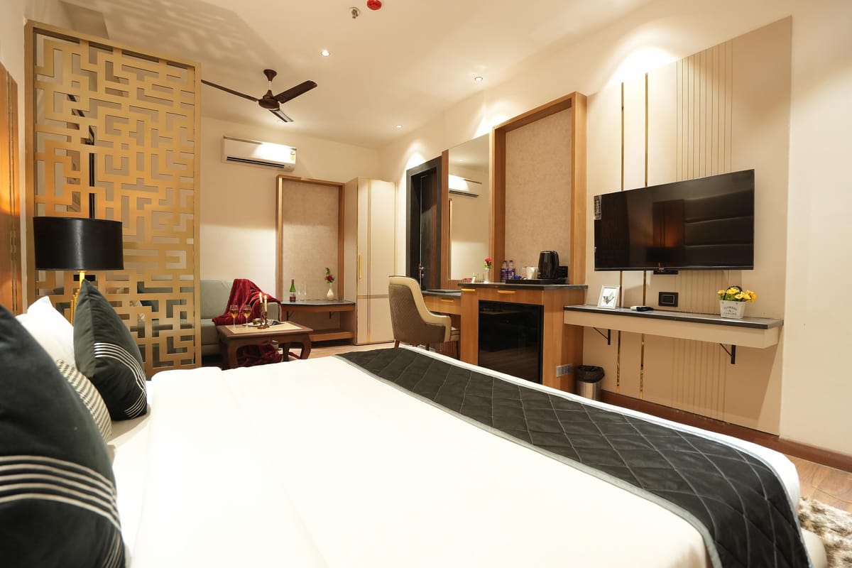 A Suite at Aura Bliss, with a carved gold screen dividing the room, a wall-mounted television
