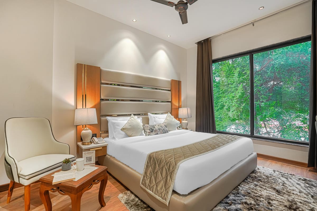 A Superior room at Aura Bliss, with lamps on both bedside tables, an armchair in the corner and a wide window