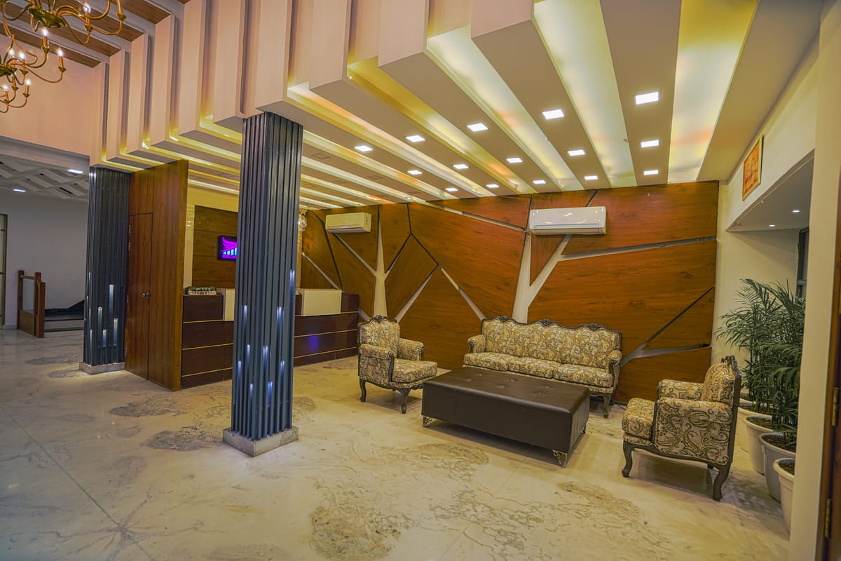 The lobby at Escala Hotel, with armchairs set around a low table below a slatted timber ceiling feature