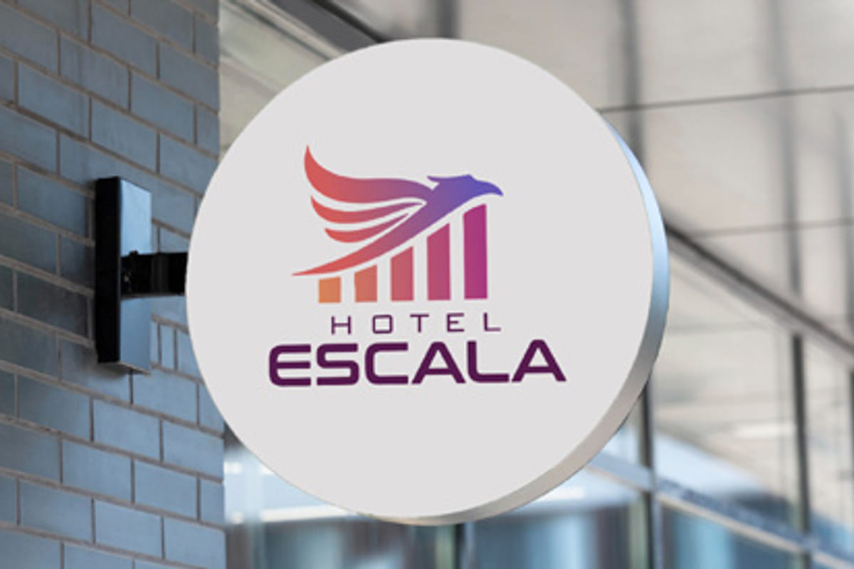 The Escala Hotel sign mounted on the brick wall beside the glass entrance, its circular panel carrying the hotel name