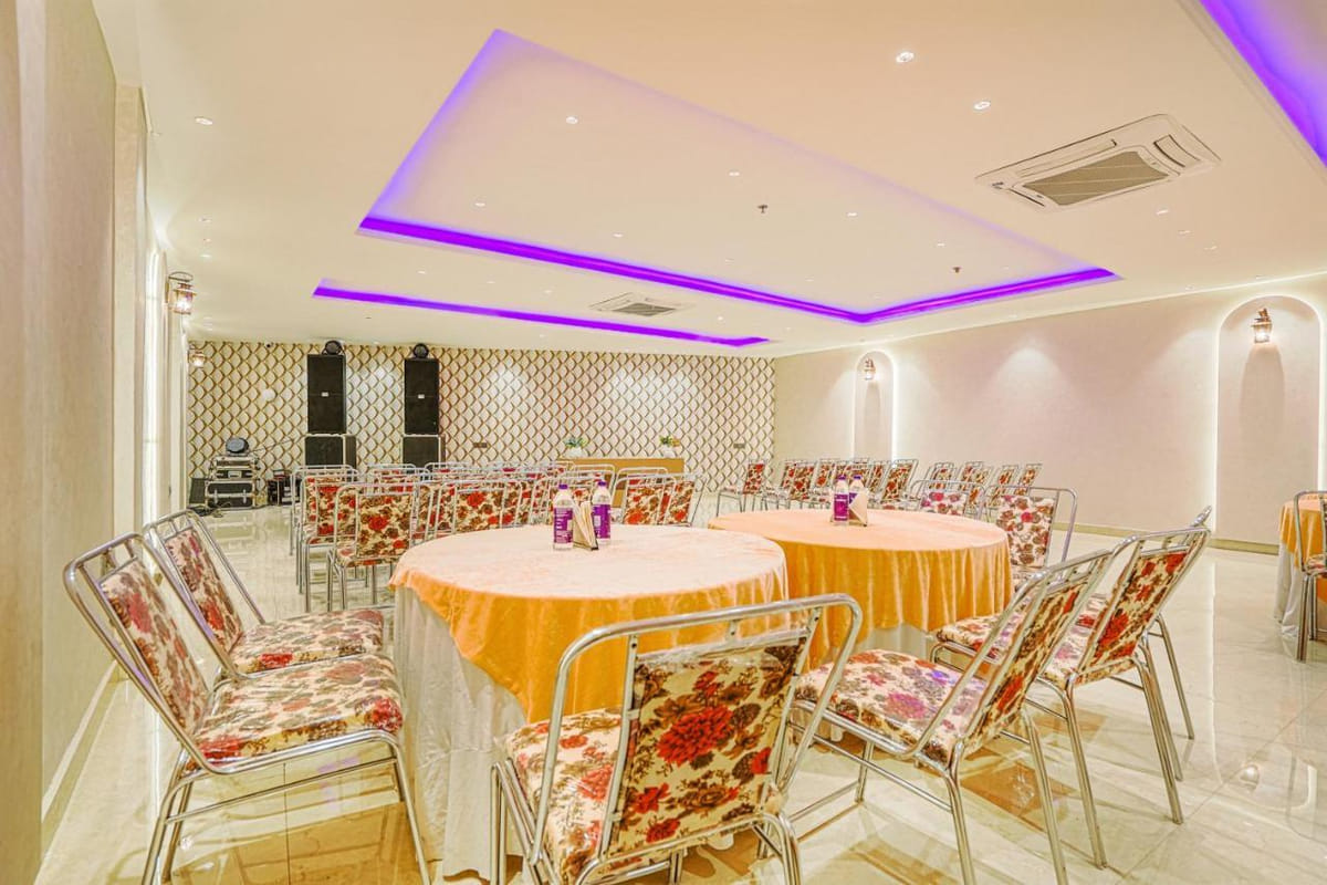The banquet hall at Grand Cabbana set with round tables under peach cloths and floral chairs