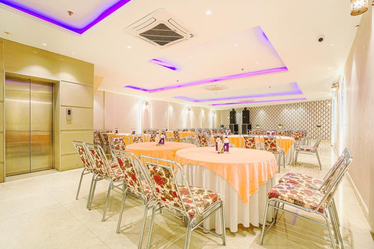 The banquet hall at Grand Cabbana set for a function with round tables and floral chairs
