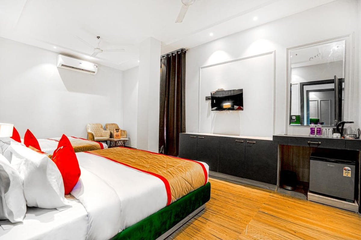 A Deluxe room at Grand Cabbana, with a wall-mounted television facing the bed, a dressing table below it