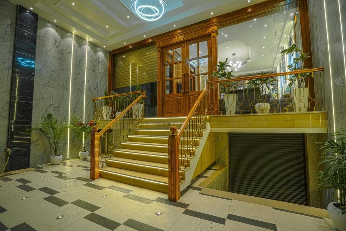 The entrance at Grand Cabbana, with wooden double doors, a brass-railed staircase up to the lobby