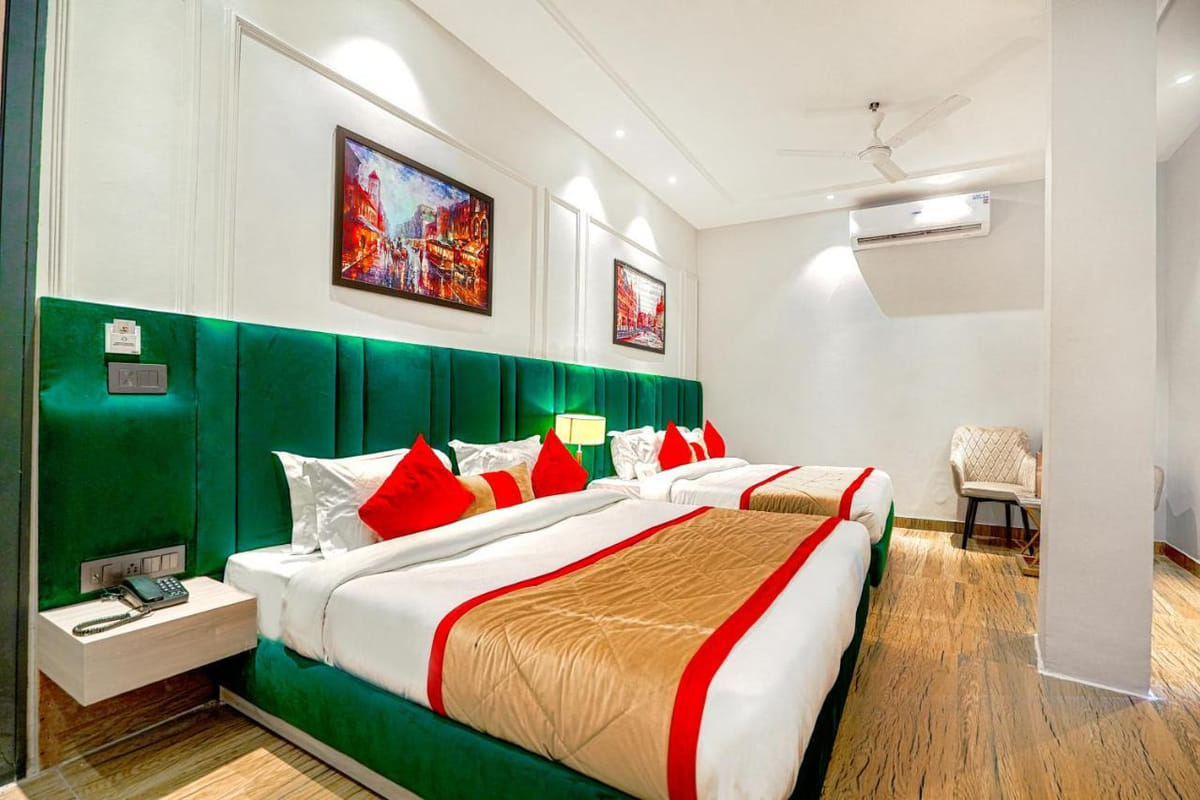 A Family Room at Grand Cabbana, with a green padded headboard, red cushions, a ceiling fan