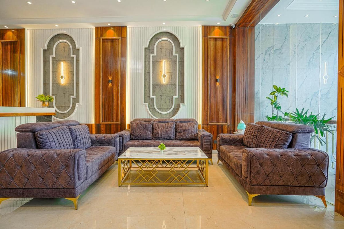 Seating in the lobby at Grand Cabbana, with tufted sofas around a gold-framed table