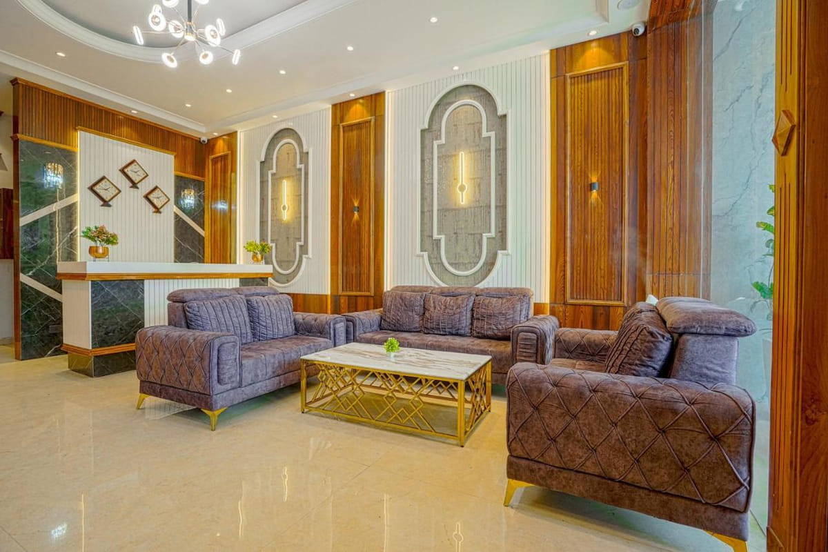 The lobby seating area at Grand Cabbana, with tufted sofas below a chandelier and the reception counter visible