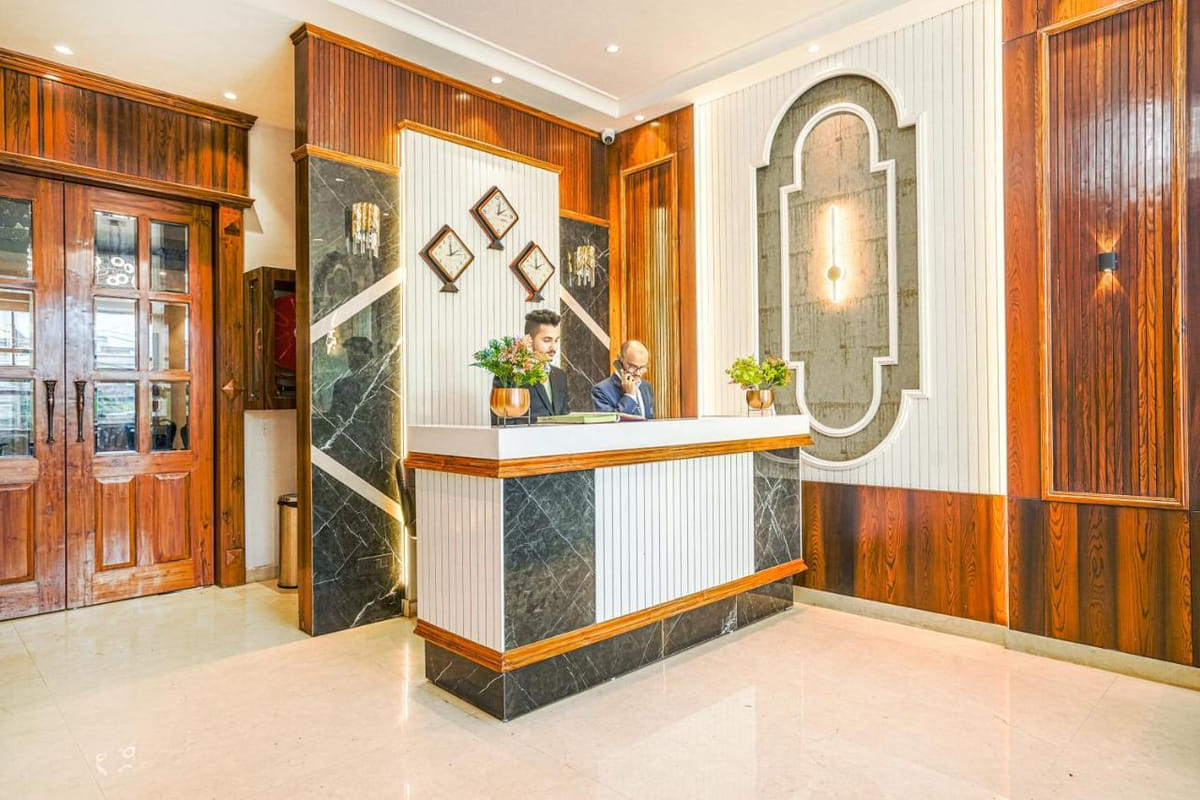 The reception at Grand Cabbana, with staff at the marble-faced counter, a row of wall clocks