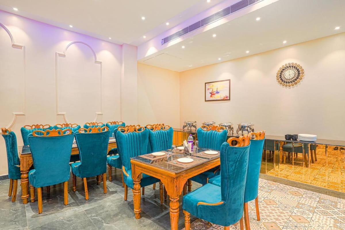 Cabbana Cafe at Grand Cabbana, with teal high-backed chairs around wooden tables on a patterned tile floor